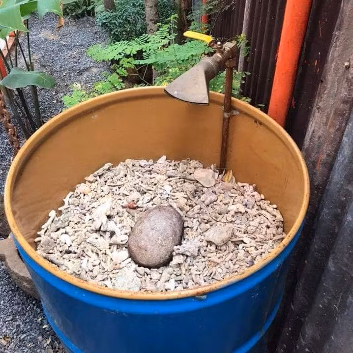 Bồn rửa tay được thiết kế bằng thùng phi cũ và sỏi. Thiết kế này giúp khử mùi và thân thiện với môi trường.