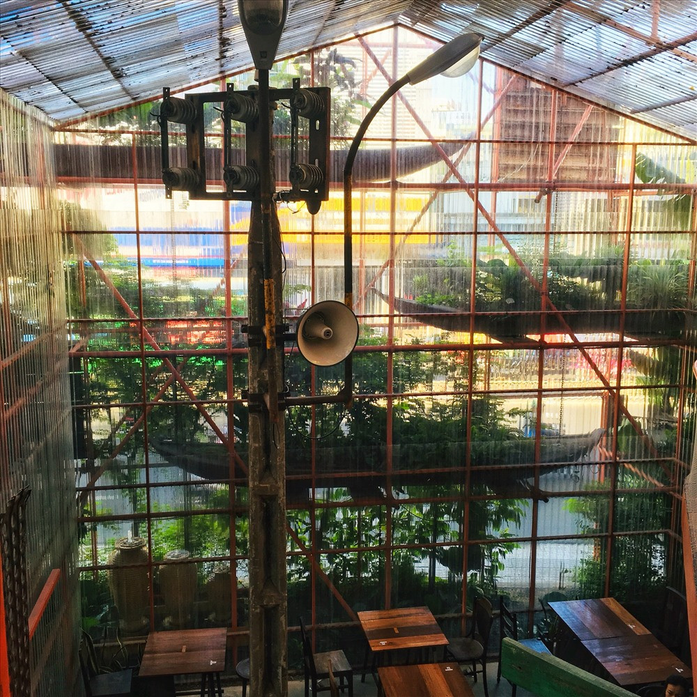 Không gian bên trong quán cà phê làm từ giàn giáo được trang trí bằng các món đồ đã qua sử dụng. Sự thông thoáng kết hợp với cây xanh mang lại một không gian xanh gần gũi với thiên nhiên. Cùng với những đồ nội thất không quá nhiều chi phí nhưng lại mang đến cho bạn sự thích thú khi đặt chân đến nơi đây. Điểm nhấn của quán là cây cột điện “hoài cổ“, ngồi trong quán nhưng cảm giác y như ngồi ngoài phố.