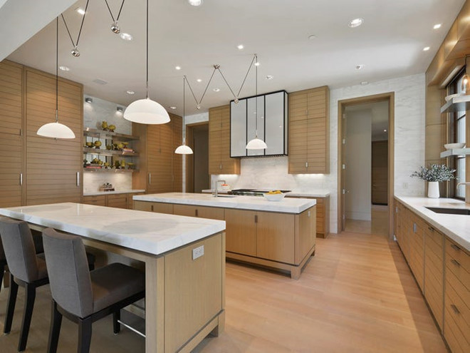 Nhà bếp rộng lớn với các bàn đá cẩm thạch, những chiếc tủ gỗ sồi trắng và một số trang thiết bị nấu nướng cao cấp.