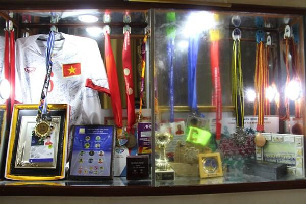 Đặc biệt, phía ngoài còn có 1 chiếc bàn đá nhỏ dùng để uống nước. Bên trong nhà cũng như những gia đình trung lưu khác, có tủ để đồ, kệ ti vi… và tất nhiên không thể thiếu 1 góc riêng dành cho huy chương, bằng khen, áo đấu và những vật kỉ niệm của con trai cưng.