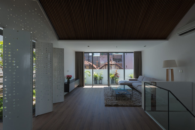 Toàn bộ sàn được lát gỗ, tạo chiều sâu và độ rộng thoáng. Phần diện tích nhỏ phía trước được bố trí làm phòng khách.