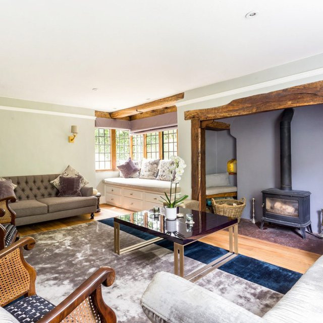 Phòng khách được tăng thêm sang trọng bằng tấm thảm lụa lớn cùng ghế sofa và đệm nhung. Chủ nhà vẫn giữ lại các lò đốt gỗ và dầm gỗ của căn nhà cũ để tưởng niệm.