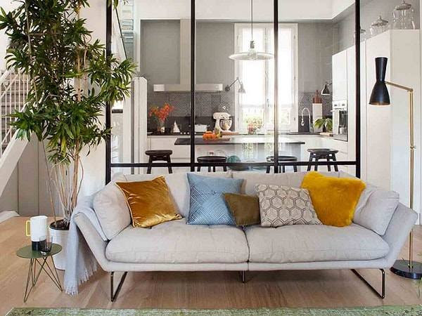 II. Các loại thiết kế vách ngăn phòng khách và bếp 1. Thiết kế vách ngăn phòng khách bằng kính Không thể phủ nhận rằng, kính đã trở thành chất liệu được các hộ gia đình ưa chuộng sử dụng trong nhà từ: cửa kính, bàn kính, tủ kính,… Chính vì lẽ đó, bên cạnh vách ngăn phòng khách và cầu thang, các nhà thiết kế đã đưa ra giải pháp tạo vách ngăn phòng khách và bếp bằng kính vừa tinh tế vừa hiện đại. Vách ngăn bằng kính tạo sự thông thoáng liền mạch giữa hai gian phòng, giúp căn phòng hấp thụ được đầy đủ ánh sáng hơn.