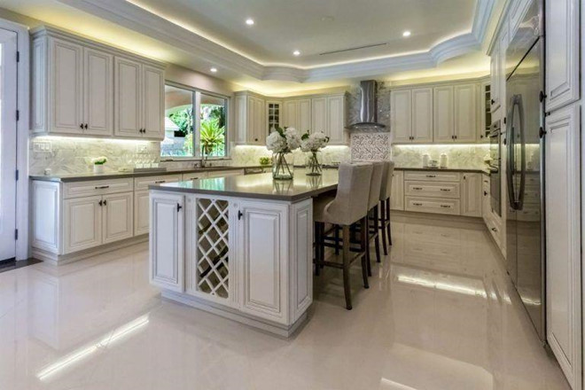 Nhà bếp với tông màu trắng chủ đạo và những chiếc tủ gỗ được lát đá cẩm thạch.