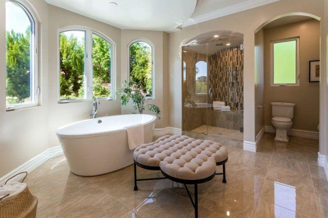 Phòng tắm chính được lát đá cẩm thạch và chia thành nhiều khu vực khác nhau. Những ô cửa sổ bao quanh giúp không gian nơi đây trở nên thoáng đãng.