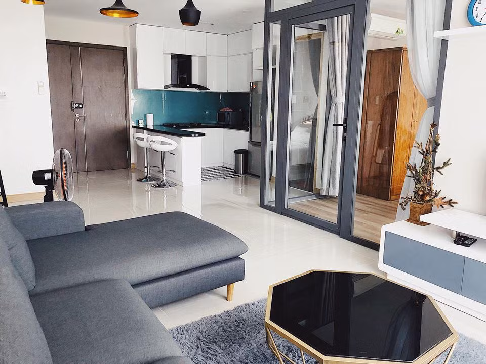 Căn hộ tuy không quá rộng nhưng vẫn đầy đủ tiện nghi, được thiết kế theo phong cách trẻ trung với nhiều mảng màu kết hợp hài hòa, khá sáng và thoáng. Ngay gần phòng khách là cửa kính dẫn vào phòng ngủ của Phương Trang, tiếp đến là khu bếp được lát gạch đen trắng độc đáo.