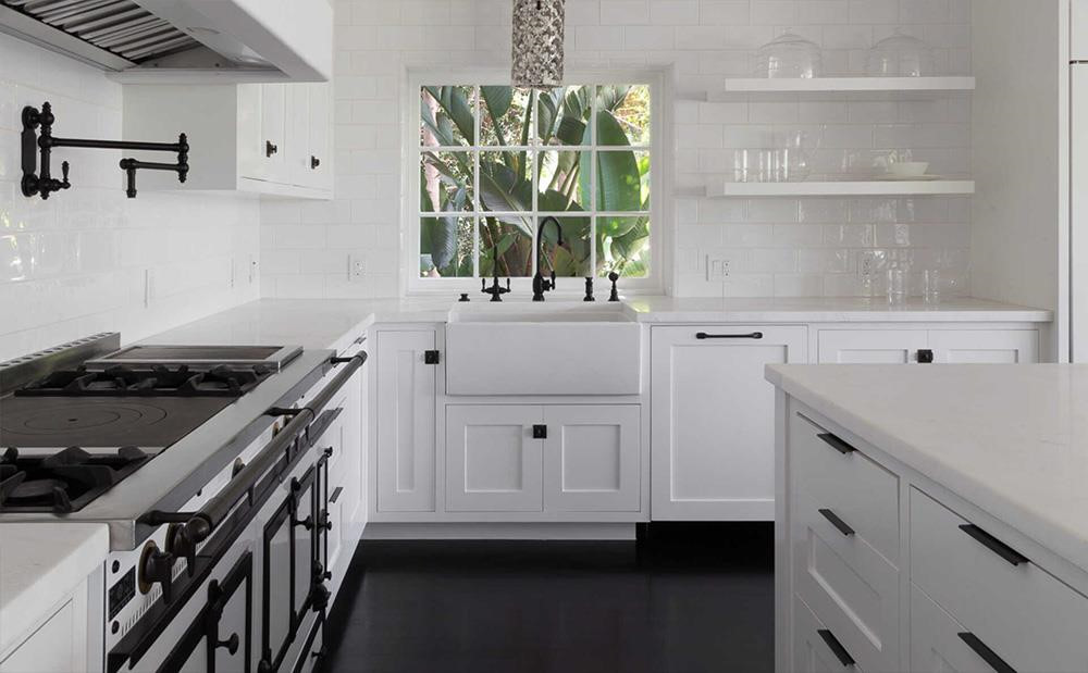 Nhà bếp có tông màu trắng chủ đạo với đồ nội thất được lát đá cẩm thạch cùng ô cửa sổ mở ra cảnh sắc sân vườn, đem đến sự thoáng đãng cho không gian.