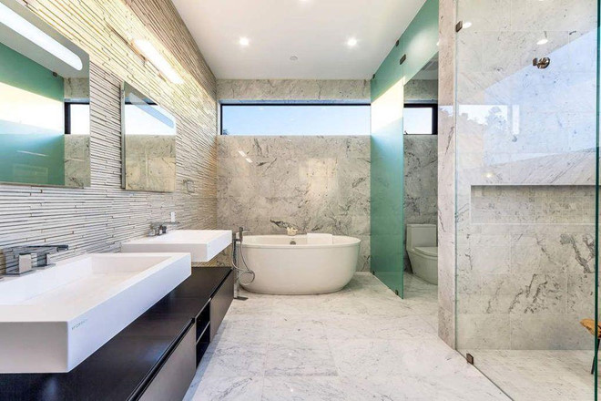 Phòng tắm chính bên trong biệt thự với sàn đá cẩm thạch, bồn ngâm, vòi sen, cùng bàn trang điểm cỡ lớn.