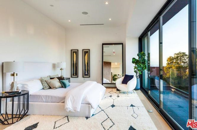 Phòng ngủ chính với những tấm cửa kính rộng lớn giúp nhận nhiều ánh sáng tự nhiên, đón ánh bình minh với cảnh sắc Los Angeles.
