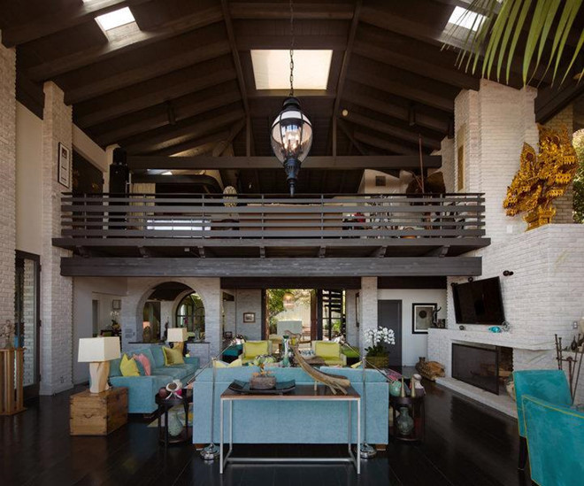 Không gian bên trong biệt thự là sự kết hợp đan xen giữa tường gạch và sàn gỗ. Giếng trời, trần nhà cao cung cấp ánh sáng tự nhiên, hòa quyện với đồ nội thất sặc sỡ.