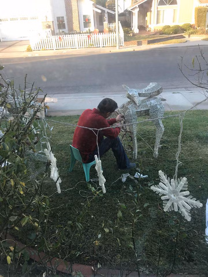 Phía bên ngoài căn nhà có sân cỏ rộng và gần đường. Dù trời lạnh, ông xã của hoa hậu Hà Kiều Anh vẫn ngồi sửa con tuần lộc và treo đèn trang trí giúp các con.