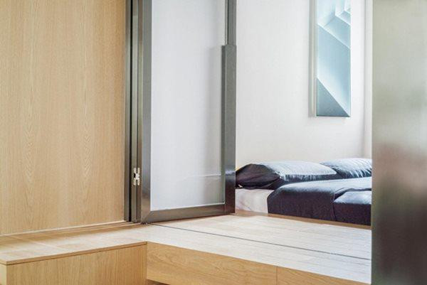 Để có được 2 yếu tố này, chủ nhà sắp xếp không gian riêng tư và chung sau đó bố trí quanh một vách tường ở trung tâm căn nhà. Không gian mở nhưng vẫn đảm bảo được sự riêng tư thông qua loạt cửa kính mờ gấp ở phòng ngủ. Những cửa kính gấp này có thể hút ánh sáng ban ngày từ cửa sổ vào căn hộ giúp tăng độ sáng.