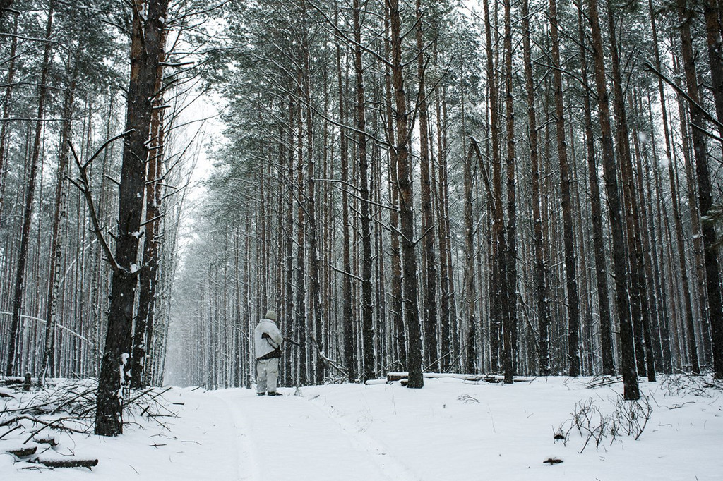 Một thợ săn đang đi săn sói ở vùng rìa của khu vực cách ly. Kể từ khi thảm họa hạt nhân xảy ra, vùng đất này vắng bóng con người và đó là lý do các loài động vật hoang dã, bao gồm chó sói, phát triển mạnh về số lượng.