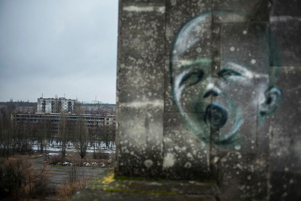 Một hình vẽ grafiti trên tường một công viên trong khu vực, vốn luôn có cảm giác rất u ám. Đằng xa là lò phản ứng số 4, nơi xảy ra vụ tai nạn lịch sử vào năm 1986.