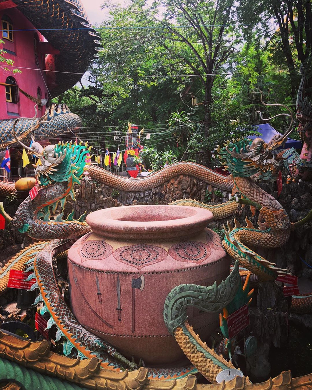 Dưới chân tháp, du khách có thể ngạc nhiên bởi hình ảnh đầy màu sắc của những lá cờ, ruy băng và đồ trang trí được các nhà sư và du khách đặt ở đó nhiều năm qua. Vườn và khu vực xung quanh được trang trí với nhiều bức tượng và hình động vật. Ảnh: Backpackjack_22.jpg, Elphi69.