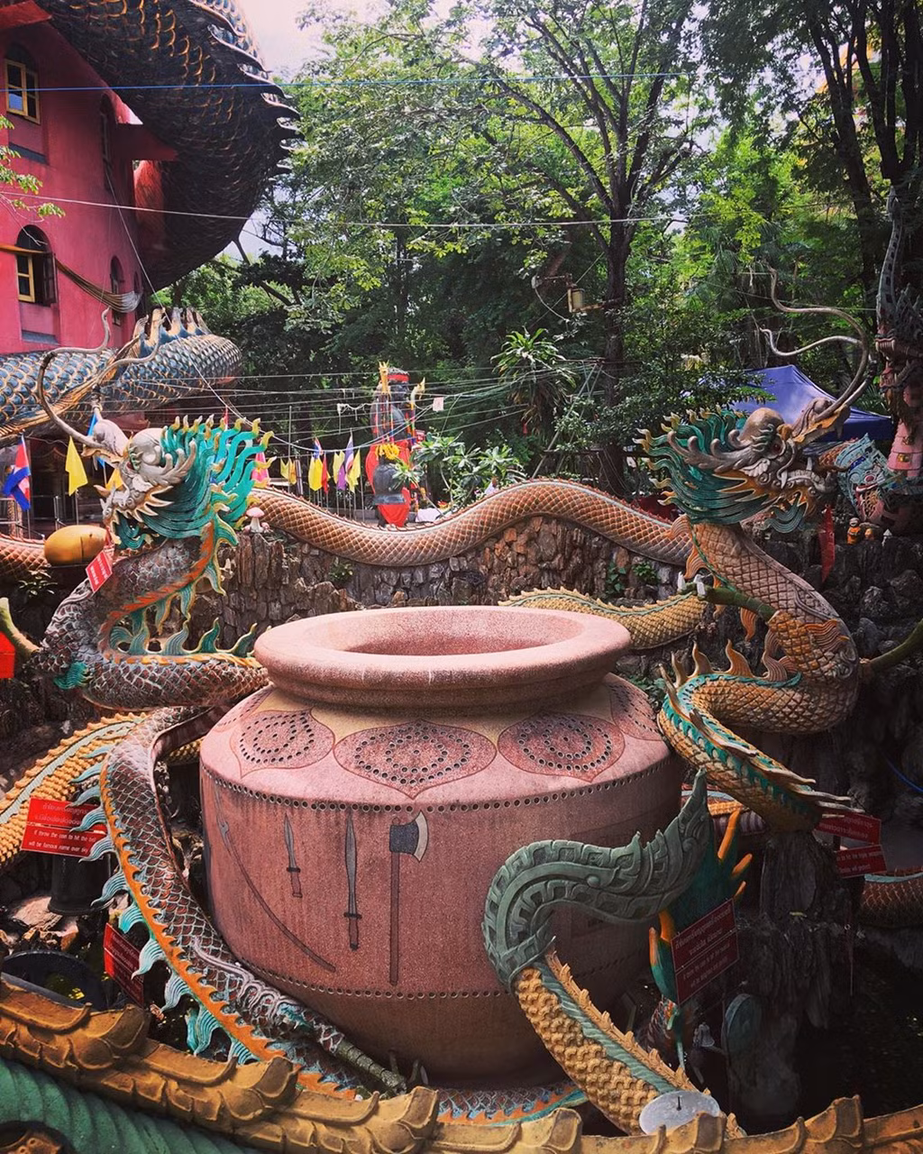 Dưới chân tháp, du khách có thể ngạc nhiên bởi hình ảnh đầy màu sắc của những lá cờ, ruy băng và đồ trang trí được các nhà sư và du khách đặt ở đó nhiều năm qua. Vườn và khu vực xung quanh được trang trí với nhiều bức tượng và hình động vật. Ảnh: Backpackjack_22.jpg, Elphi69.