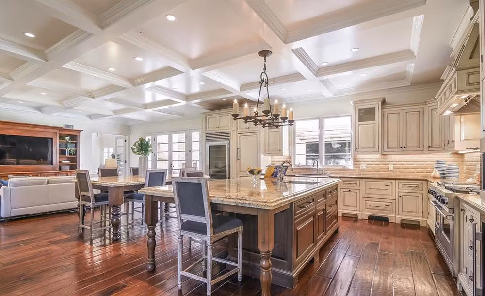 Giữa nhà bếp là bàn đá cẩm thạch cùng khu vực ăn uống. Một không gian gia đình nhỏ với tủ TV được tích hợp tại đây, nơi mọi người có thể thư giãn trong lúc chờ bữa ăn.