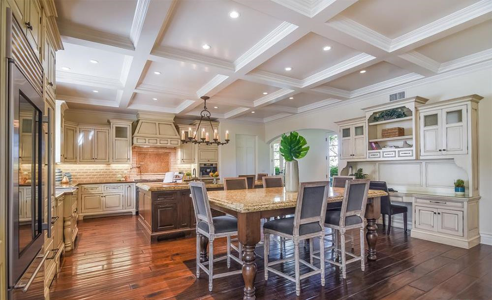 Nhà bếp với tông màu ấm, nội thất bằng gỗ cùng những trang thiết bị nấu nướng hiện đại như tủ lạnh, máy rửa chén, lò nướng, máy pha cà phê...