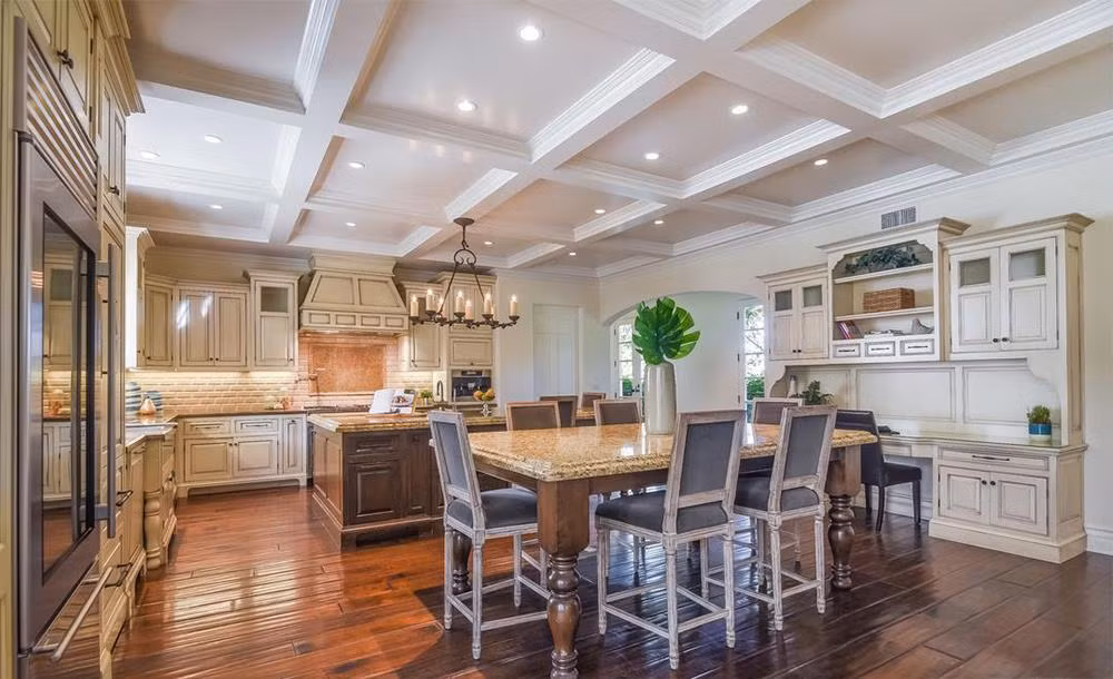 Nhà bếp với tông màu ấm, nội thất bằng gỗ cùng những trang thiết bị nấu nướng hiện đại như tủ lạnh, máy rửa chén, lò nướng, máy pha cà phê...