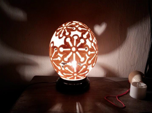 Mỗi vỏ quả trứng ngỗng để trong hộp gắn đèn led chị bán với giá khoảng 300.000 đồng/sản phẩm. Những họa tiết khắc trên vỏ trứng chủ yếu là hoa lá, trang trí đối xứng, chữ… hoặc có thể khách hàng yêu cầu thì chị Vinh sẽ làm theo. Khách đặt hầu như phải chờ làm, vì không thể làm xong ngay lập tức được.