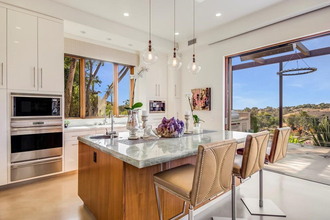 Nhà bếp với bàn đá thạch anh và thiết bị hiện đại, được thiết kế mở với những ô cửa rộng lớn. Biệt thự còn có một hầm rượu chứa 750 chai rượu vang.