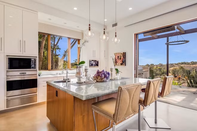 Nhà bếp với bàn đá thạch anh và thiết bị hiện đại, được thiết kế mở với những ô cửa rộng lớn. Biệt thự còn có một hầm rượu chứa 750 chai rượu vang.