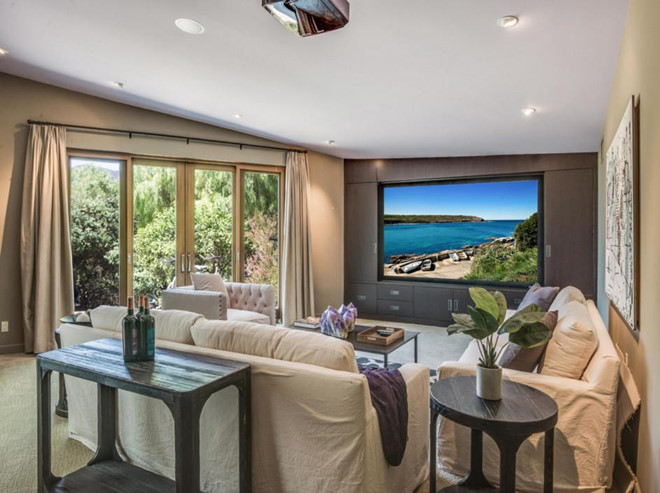 Phòng khách được tích hợp cùng một khu vực chiếu phim với màn hình, máy chiếu, và hệ thống âm thanh hiện đại.