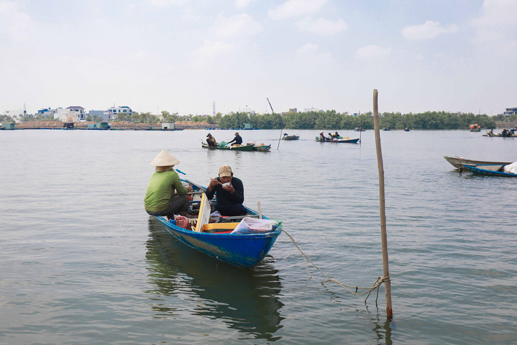 Trong khi chờ thành viên khác lặn ngụp phía dưới bắt vẹm, người ngồi trên ghe tranh thủ ăn trưa.