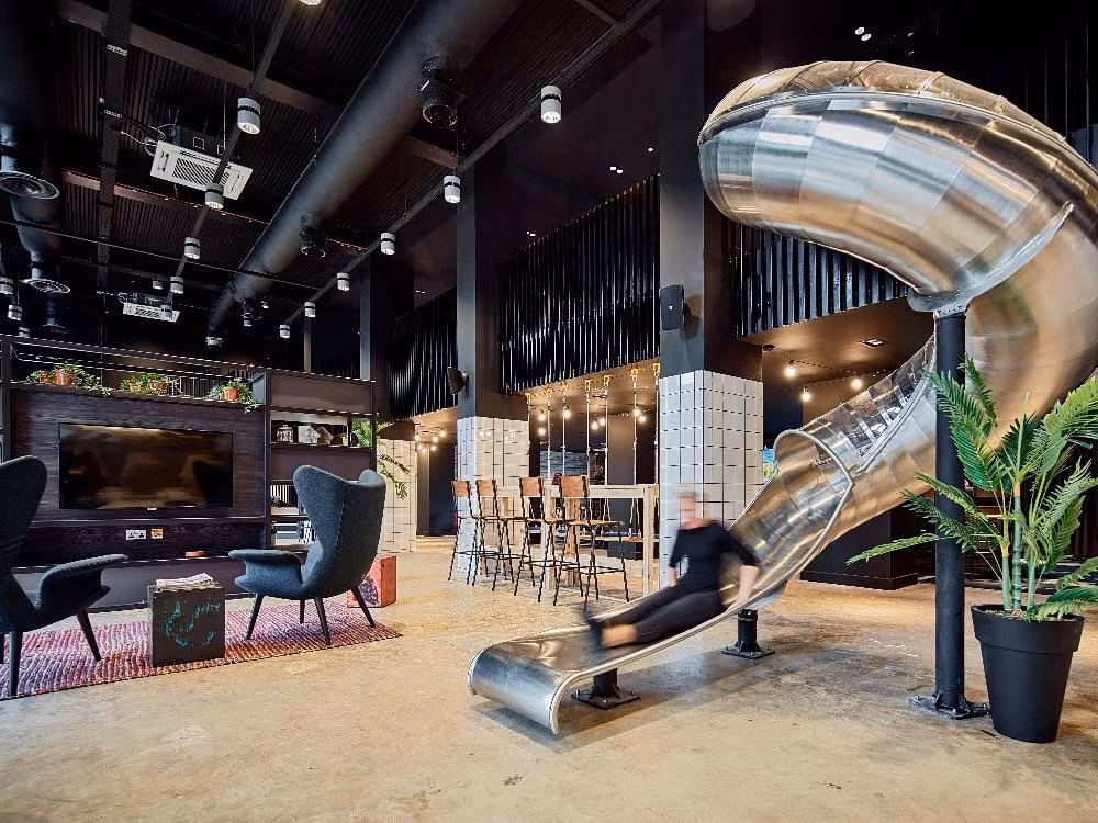 True Glasgow: 7.040-10.710 bảng/năm. Không gian giải trí dành cho chủ nhân các căn phòng tại True Glasgow thực sự sang trọng. Một ống trượt lớn được nối từ tầng 1 xuống tầng trệt. Từng thành viên trong khu ký túc xá này được chăm sóc bởi một đội ngũ chuyên nghiệp và có hẳn một phòng chiếu phim 4k tiêu chuẩn như ở rạp. Ảnh: Mystudenthalls.com.