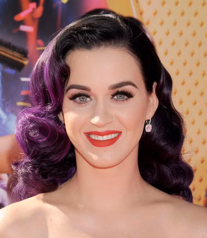 Mái tóc xoăn tím đầy sức hút của Katy Perry được lấy cảm hứng từ nữ diễn viên Veronica Lake - ngôi sao kinh điển của làng điện ảnh Hollywood trong những năm 1940. Có thể nói kiểu tóc này và màu tím của nó vẫn còn áp dụng được trong thời đại này. Ảnh: Elle.