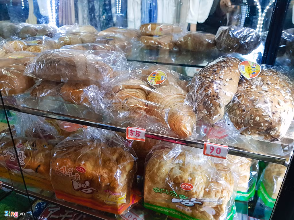 Các cửa hàng phổ biến ở Triều Tiên có diện tích khoảng 20 m2 với những tủ kính được đặt cạnh nhau với các sản phẩm khác nhau từ thịt cá, bánh mì đến bóp ví và cả nữ trang. Trong ảnh là tủ bày bán các loại bánh mì có giá dao động từ 55 won (đơn vị tiền tệ của Triều Tiên) khoảng 1.400 đồng. Tỷ giá quy đổi 1.000 won là khoảng 25.400 đồng.