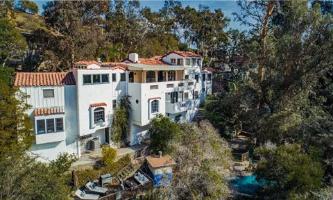 Biệt thự mang phong cách Địa Trung Hải này được xây vào năm 1938 và đã thay đổi trong những năm qua. Khi các nhà biên kịch Hollywood, Roger Simon và Sheryl Longin sở hữu ngôi nhà, nó đã có mặt tiền sặc sỡ với các màu nâu, xanh lá và hồng. Nhưng trong lần sửa chữa mới đây nhất, nó đã được phủ trắng toàn bộ. Ảnh: Coldwell Banker Residential Brokerage.