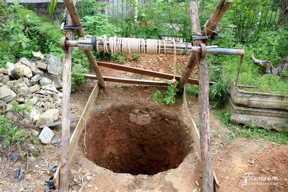 Mùa hè nắng nóng, khô hạn là thời điểm những người đào giếng hoạt động nhiều nhất. Dụng cụ của nghề đào giếng gồm cuốc, xà beng... và một bộ ròng rọc quay tay gác trên một giàn gỗ tạm. Trong ảnh: Bộ ròng rọc bắc trên miệng giếng.