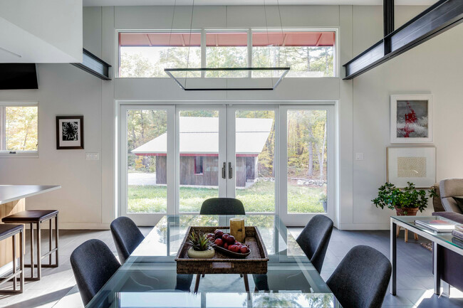 Bàn ăn có tầm nhìn hướng ra nhà kho bên ngoài cùng cánh rừng rộng lớn.