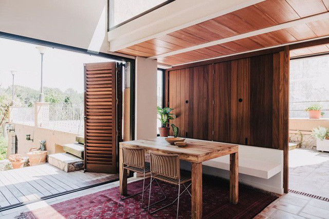 Góc đọc sách, thư giãn được đặt ngay cạnh lối vào. Bằng cách sử dụng gương treo tường có viền khung gỗ sơn đen tạo điểm nhấn sinh động và bắt mắt trên nền trắng của tường và tủ đựng đồ kê sát tường. Thêm chút sắc màu tự nhiên từ ghế tựa và chậu cây để góc nhỏ thư giãn thêm ấn tượng.