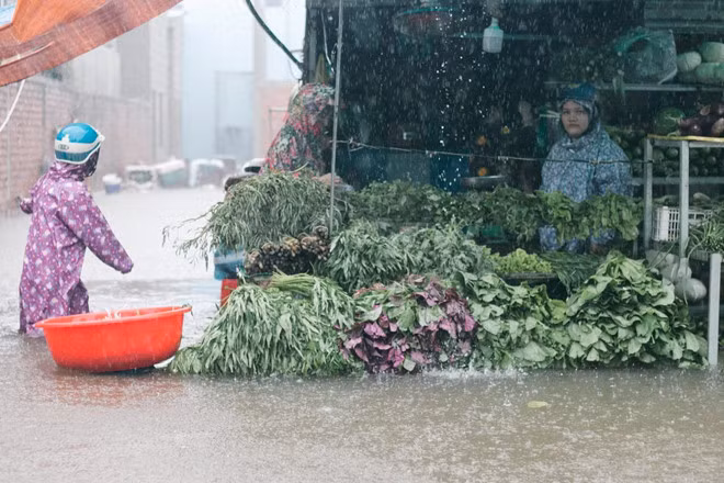 Dù mưa lớn, ngập sâu, các tiểu thương vẫn cố gắng duy trì việc buôn bán để cung cấp nhu yếu phẩm cho người dân đảo ngọc.