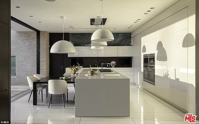 Nhà bếp rộng lớn được trang bị hẳn một khu vực ăn uống riêng. Các trang thiết bị hiện đại, cao cấp được tích hợp trong những chiếc tủ cỡ lớn có màu kem.