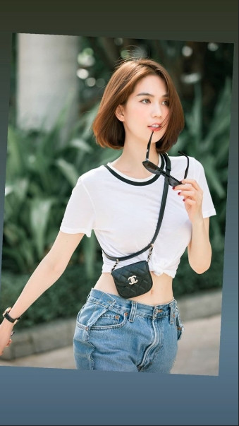Chân dài Trà Vinh phối chiếc quần có thiết kế lạ mắt này với áo phông body vén lên thành croptop, túi mini của Chanel và sneaker hầm hố của Prada.