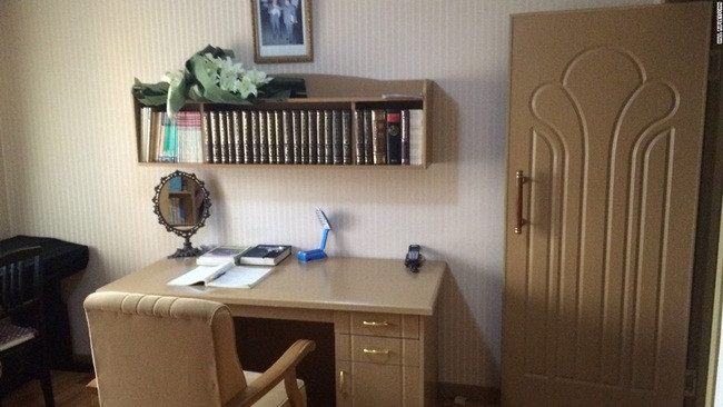 Bàn làm việc trong căn hộ. Sách được xếp ngay ngắn trên bàn. Phía trên bàn có treo hình ảnh của cố lãnh đạo Kim Nhật Thành và cố lãnh đạo Kim Jong-il.