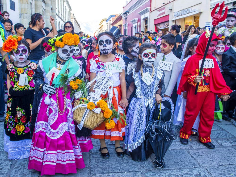 Lễ hội Día de los Muertos (Mexico): Từ ngày 1-2/11, Mexico và nhiều nơi khác ở châu Mỹ Latinh tổ chức Día de los Muertos (Ngày của người chết). Theo quan niệm, cổng thiên đường mở cửa lúc nửa đêm ngày 31/10, linh hồn trẻ em sẽ trở về Trái Đất đoàn tụ với gia đình trong 24 giờ. Vào ngày 2/11, linh hồn người trưởng thành từ thiên đàng xuống để tham gia vào lễ hội. Bàn thờ trong mỗi nhà trang trí hoa quả, đậu phộng, gà tây, soda... và bánh mì "Pan de muerto" đặc trưng. Ngoài ra, các gia đình chuẩn bị kẹo, đồ chơi, thuốc lá hoặc rượu để tưởng niệm người đã khuất. Ảnh: Readersdigest.