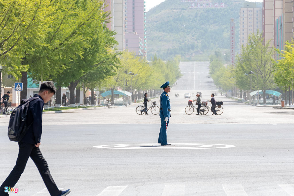 Một cảnh sát giao thông làm nhiệm vụ trên đường phố Khai Thành. Đây là một thành phố ở tỉnh Bắc Hwanghae, phía nam của Triều Tiên. Thành phố này là trung tâm công nghiệp nhẹ của đất nước.