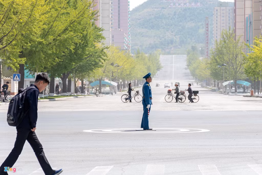 Một cảnh sát giao thông làm nhiệm vụ trên đường phố Khai Thành. Đây là một thành phố ở tỉnh Bắc Hwanghae, phía nam của Triều Tiên. Thành phố này là trung tâm công nghiệp nhẹ của đất nước.