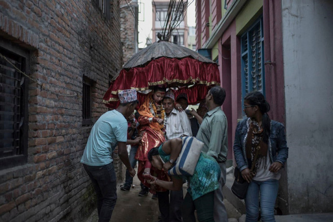 Những người họ hàng là nam giới đang rước Unika, người từng là nữ thần sống của Patan, đến ngôi đền nơi em ở. Unika, 11 tuổi, nói với nhiếp ảnh gia Contreras Coll rằng trong thời gian làm Kumari, “điều em thích nhất là làm người khác vui”. Ảnh: Maria Contreras Coll.