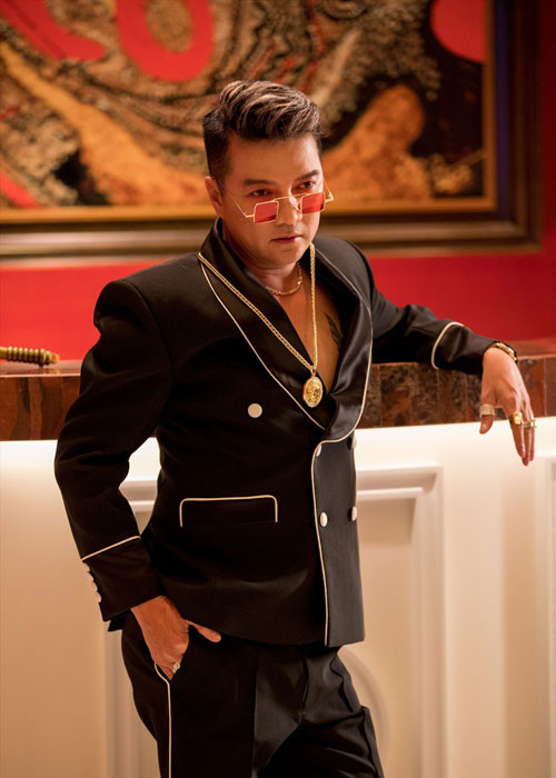 Mr Đàm phối trang phục với loạt phụ kiện mắt kính, dây chuyền, nhẫn đắt tiền. Ảnh: Laodong