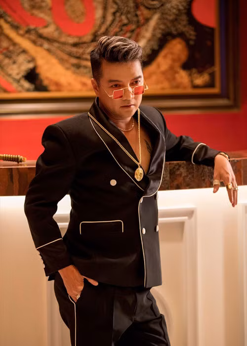 Mr Đàm phối trang phục với loạt phụ kiện mắt kính, dây chuyền, nhẫn đắt tiền. Ảnh: Laodong