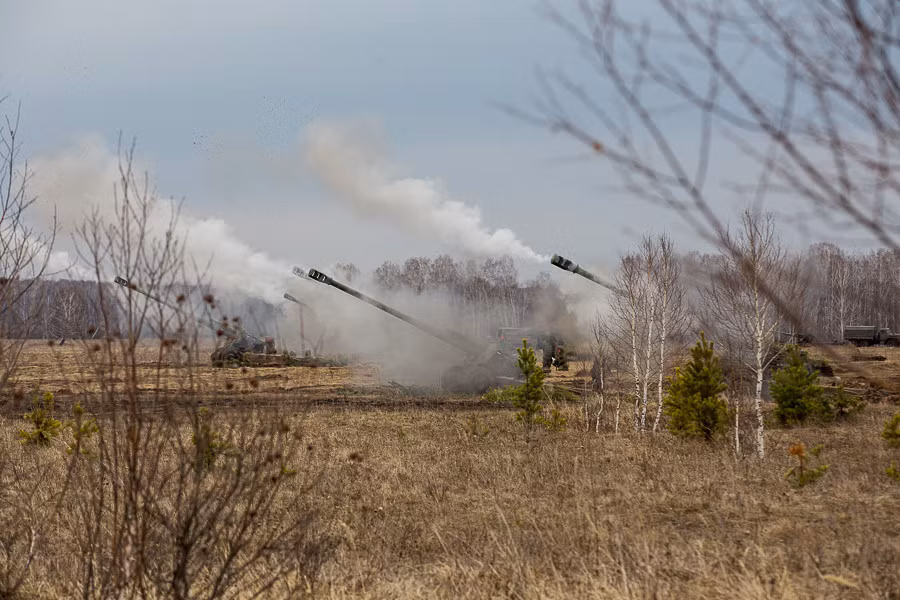 Khẩu đội lựu pháo 2A65 Msta-B đồng loạt nhả đạn dội bão lửa lên mục tiêu. Ảnh: Arms Expo.