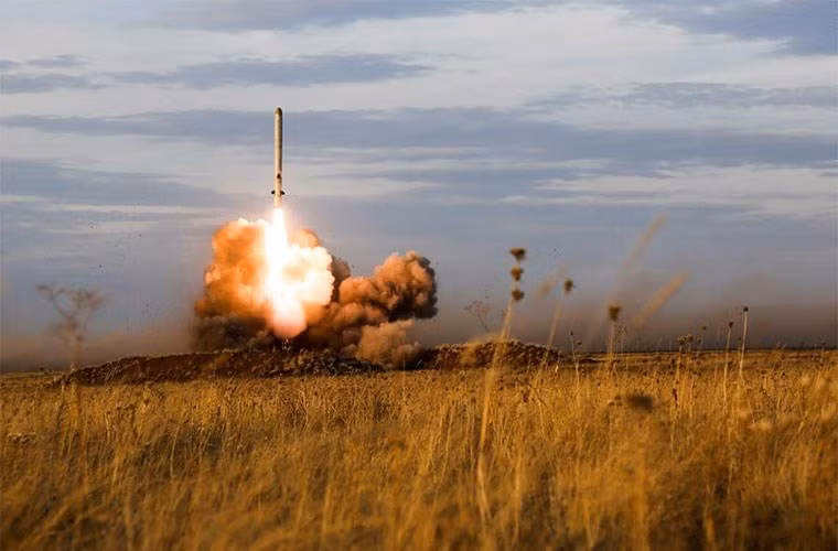 Quầng lửa và khó bụi phát ra khi hệ thống Iskander-k khai hỏa. Cũng giống như đa số các hệ thống phóng tên lửa của Liên Xô trước đây và Nga ngày nay, cơ chế phóng thẳng đứng với một động cơ nhỏ được kích hoạt đưa tên lửa ra khỏi ống phóng, sau đó động cơ chính kích hoạt để đẩy tên lửa bay đi. Nguồn ảnh: Russian strategic nuclear