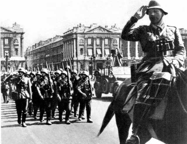 Quân Đức diễu hành trong thủ đô Paris, trớ trêu thay con đường diễu hành của phát xít Đức sẽ đi đúng với lộ trình cách đấy hơn 20 năm người Pháp đã diễu hành mừng chiến thắng trong chiến tranh thế giới thứ nhất. Nguồn ảnh: Historyimages.