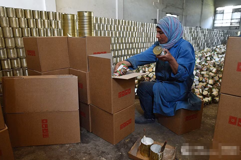 Công nhân đang đóng hàng là những đồ ăn đóng hộp.