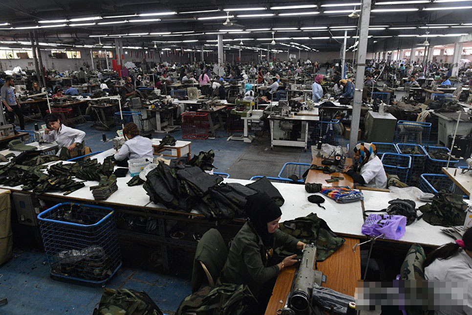 Trong ảnh là không khí nhộn nhịp trong xưởng may mặc quân trang.